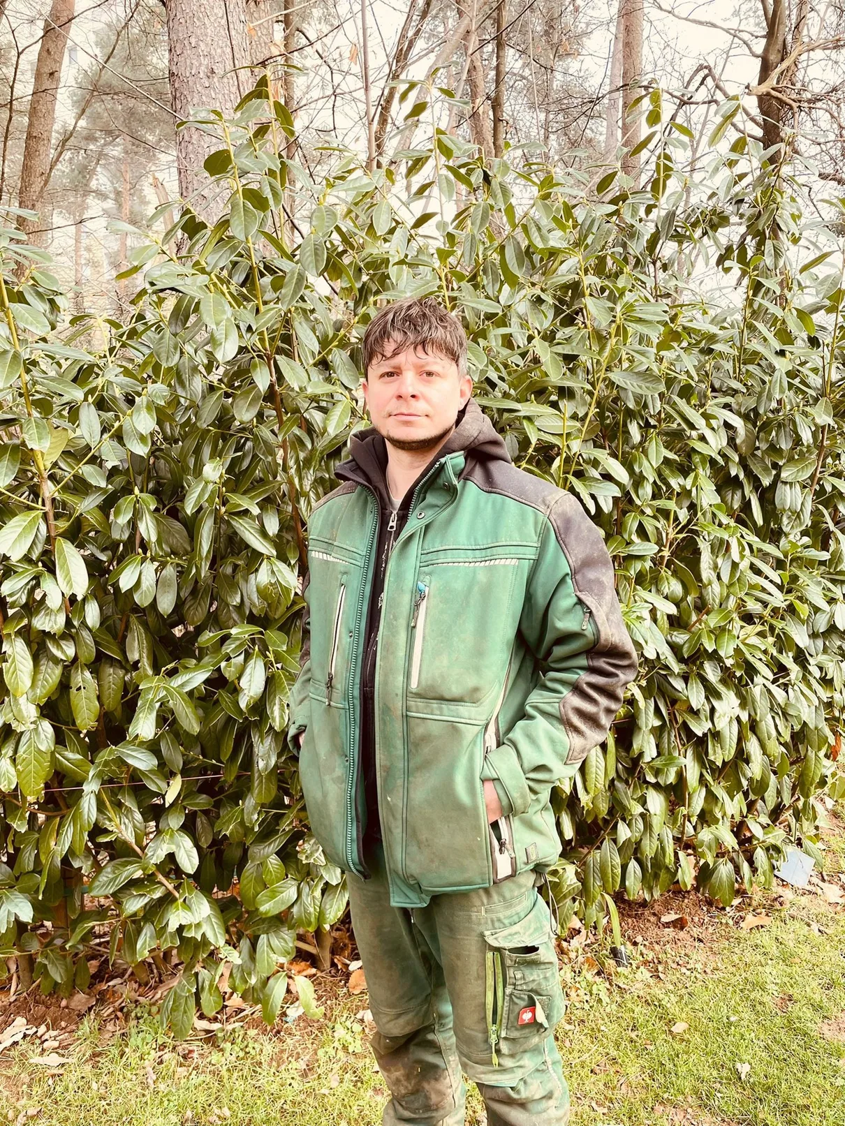 Arbnor Qeli, Inhaber von Home&Green Service, vor einer frisch geschnittenen Hecke